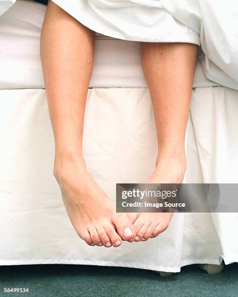 a woman getting up - feet in bed stock-fotos und bilder