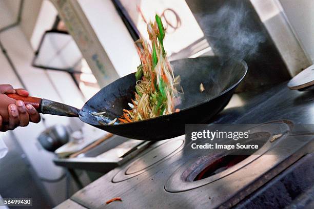 chef stir-frying vegetables - roerbakken stockfoto's en -beelden