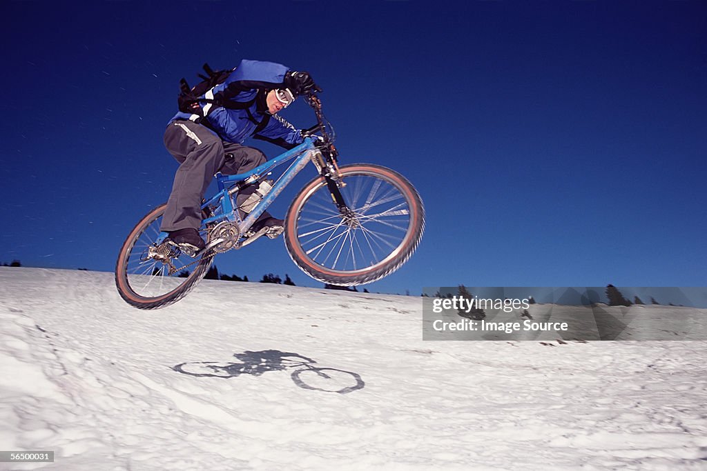 Man riding mountain bike on snow