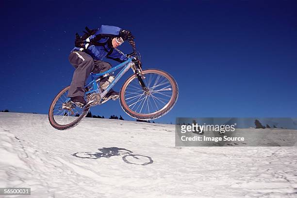 man riding mountain bike on snow - continental divide stock pictures, royalty-free photos & images