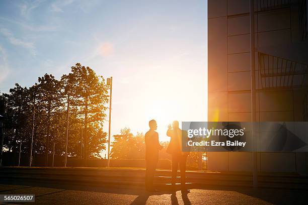 two businessmen discussing plans in sun - conversation sunset stock-fotos und bilder