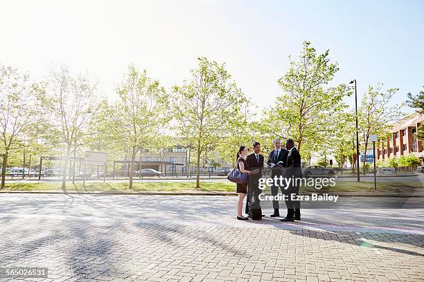 group of colleagues stand together talking outside - business meeting outside stock pictures, royalty-free photos & images