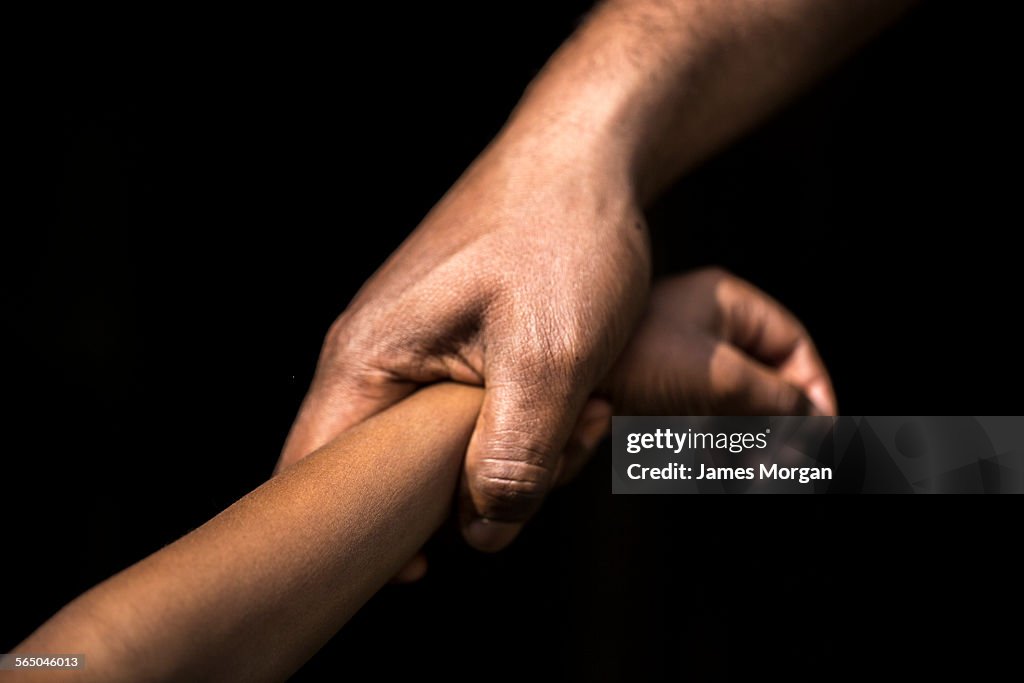 Adult holding a child's wrist