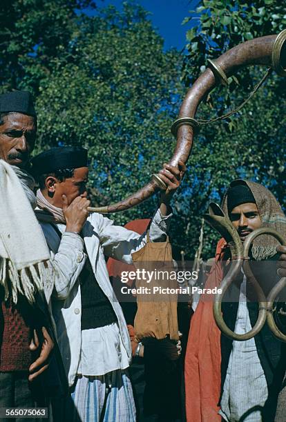 Musicians playing serpentine horns , at a festival in India, circa 1965.