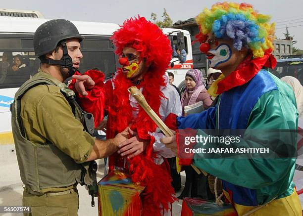 Protestors dressed as clowns argue with an Israeli during a demonstration against the closure of the Beit Ebla checkpoint near the West Bank city of...