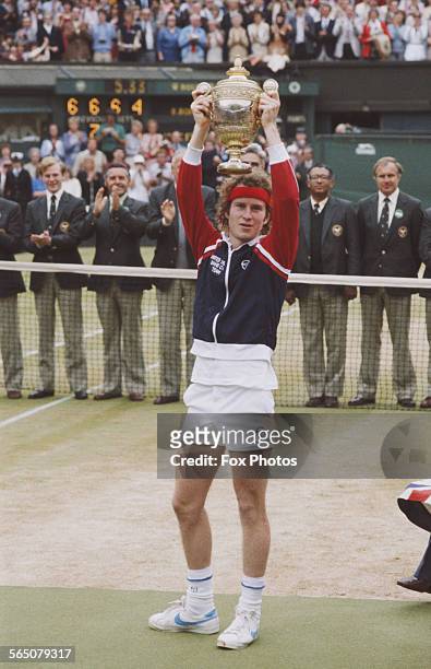 John McEnroe of the United States holds the trophy aloft after defeating Bjorn Borg during the Men's Singles Final match at the Wimbledon Lawn Tennis...