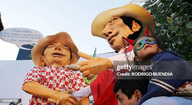 Un padre con su hija pasan junto a monigotes de un carro alegorico en una calle del centro de Quito el 31 de diciembre de 2005. Como es tradicional...