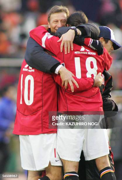 Guido Buchwald , German head coach of Japanese football club Urawa Reds, and players hug each other to celebrate their winning match at the Emperor's...