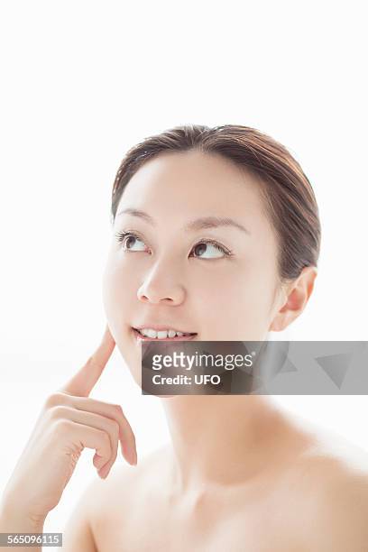 woman touching her face with finger - 若い女性 日本人 顔 ストックフォトと画像