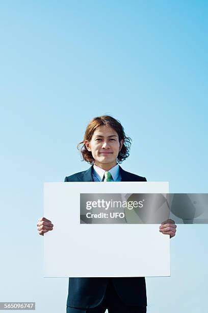 businessman holding message board - お知らせ ストックフォトと画像