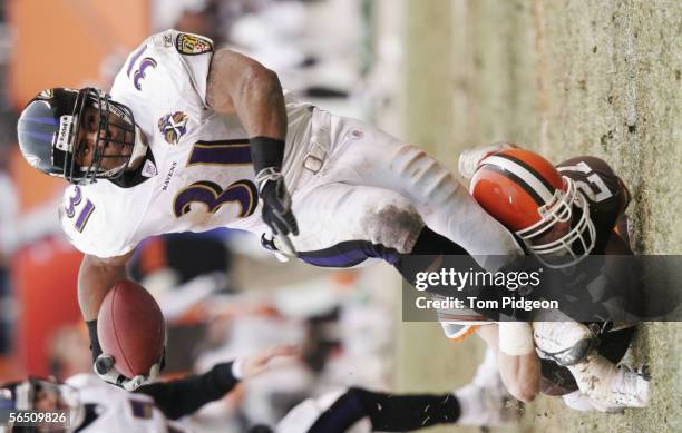 Brian Russell of the Cleveland Browns tackles Jamal Lewis of the Baltimore Ravens during a NFL game at Cleveland Browns Stadium on January 1, 2006 in...