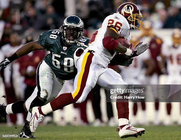 Runningback Clinton Portis of the Washington Redskins carries the ball away from Trent Cole of the Philadelphia Eagles during the first quarter of...