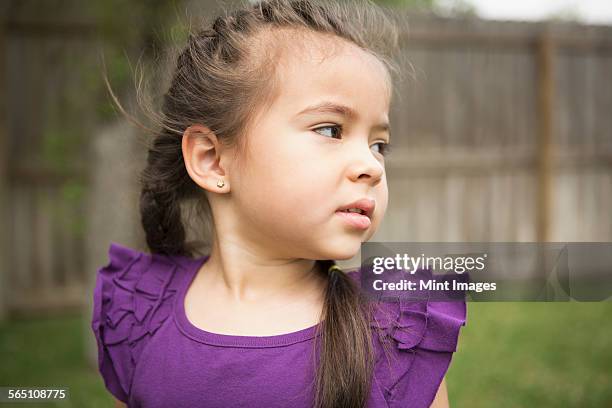 a young girl looking over her shoulder. - purple shirt fotografías e imágenes de stock