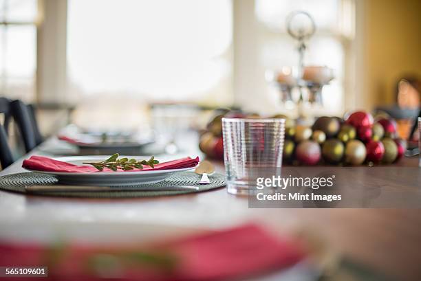 a table laid for a celebration meal. christmas ornaments, decorations and a candle in a candle holder.  - woodstock new york stockfoto's en -beelden
