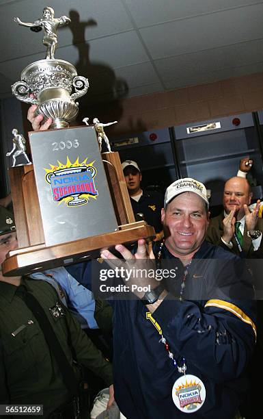 Head coach Rich Rodriguez of the West Virginia Mountaineers holds the Sugar Bowl trophy in the locker room after defeating the Georgia Bulldogs 38-35...