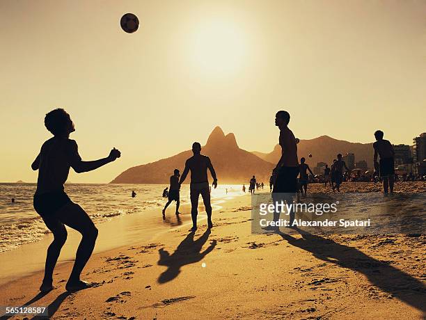 people playing football at ipanema beach in rio - rio de janeiro photos et images de collection