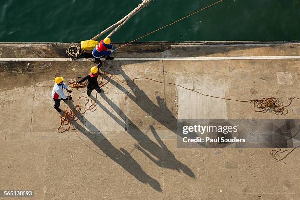 dockworkers tie up cruise ship, hong kong, china - dockarbeiter stock-fotos und bilder