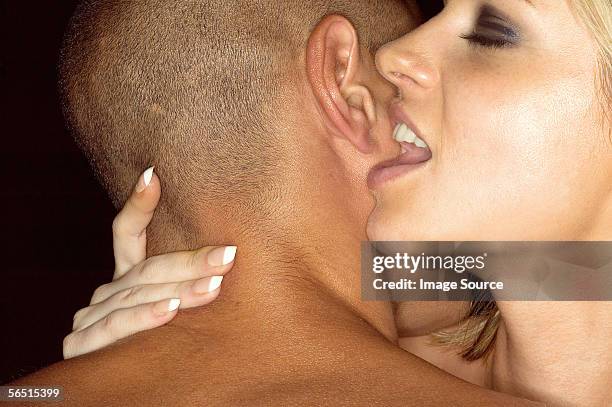 woman whispering in mans ear - whispering stock pictures, royalty-free photos & images