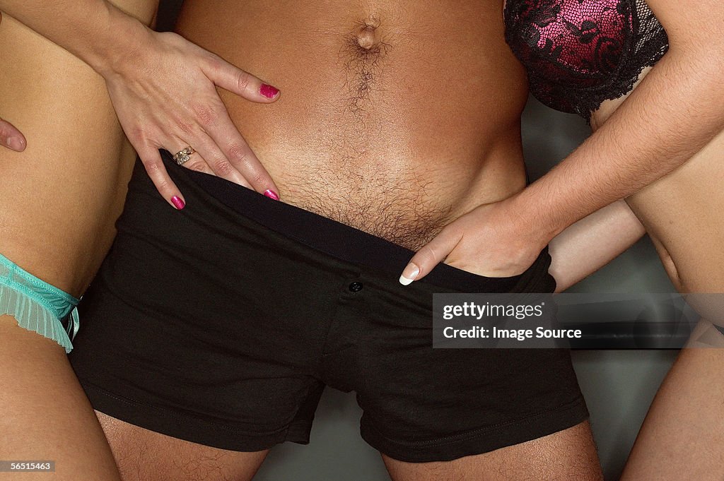 Women's hands in man's boxer shorts