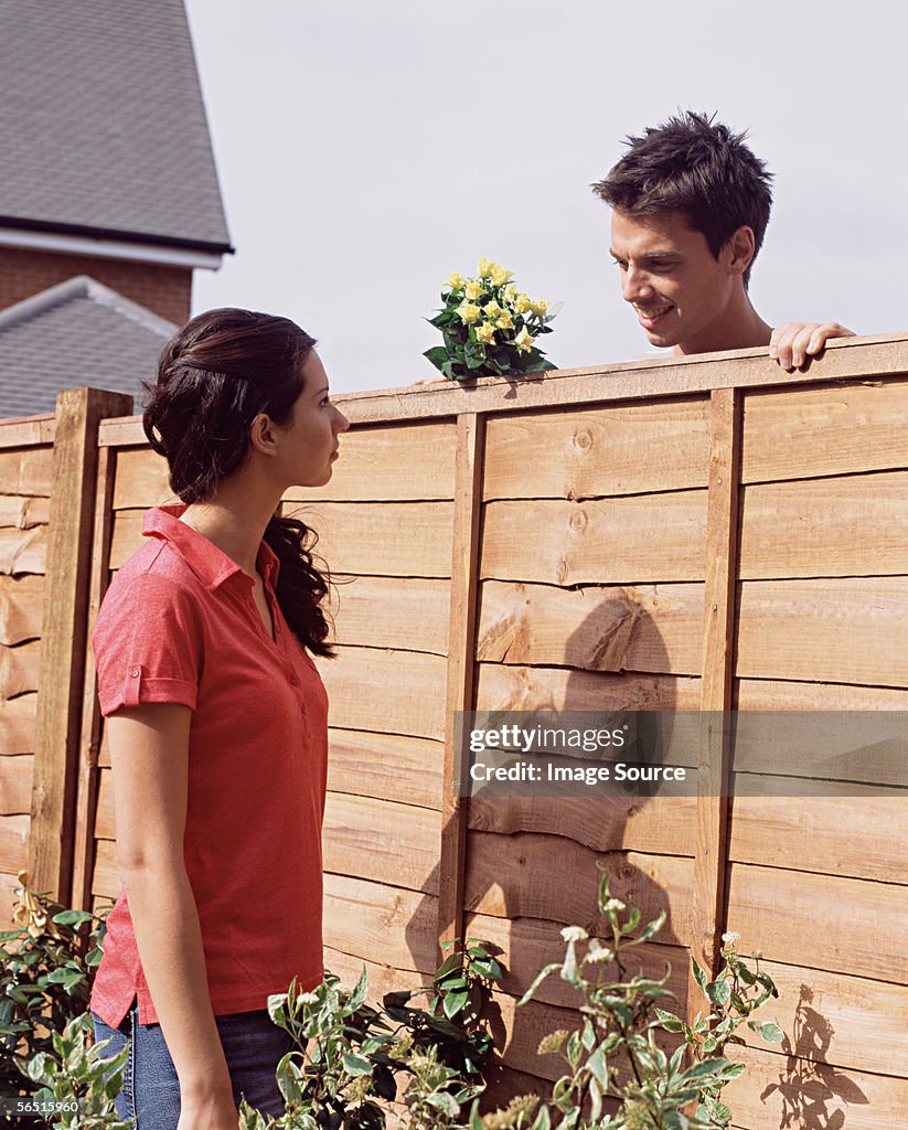 Man and woman talking over garden fence