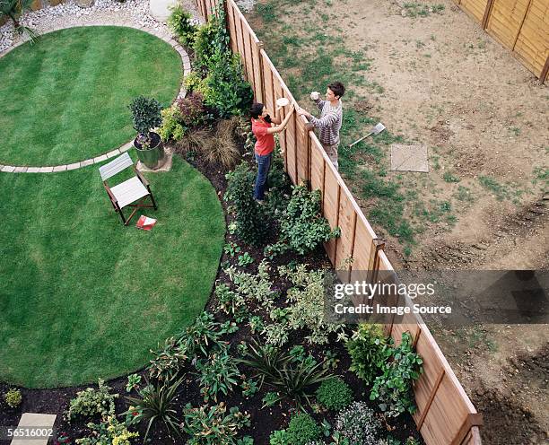 neighbours having coffee over the fence - fence stockfoto's en -beelden