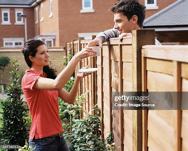 woman giving coffee to neighbour - neighbors stock-fotos und bilder