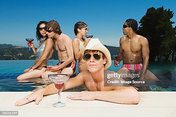 friends drinking cocktails in a swimming pool - poolside glamour stock pictures, royalty-free photos & images