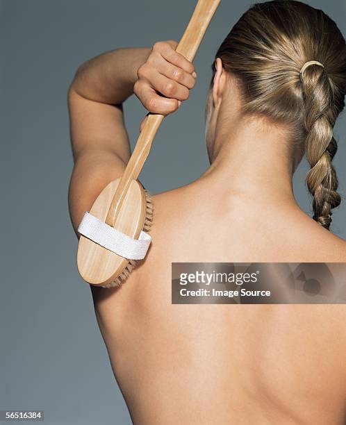woman using back brush - back brush stock pictures, royalty-free photos & images
