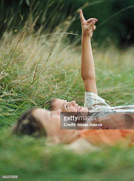 boy and girl lying on the grass - lying down stockfoto's en -beelden