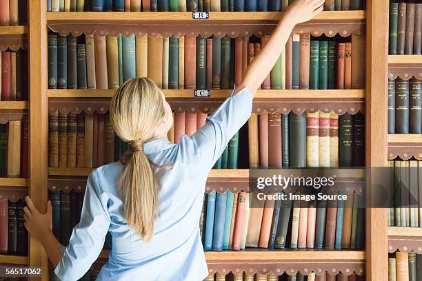 Reaching Books Reaching For Book In Library Photos and Premium High Res Pictures ...