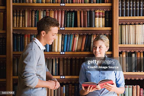 boy and girl in the library - girl flirting stock pictures, royalty-free photos & images