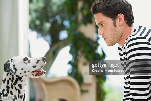 hombre y su perro - mirar fijamente fotografías e imágenes de stock