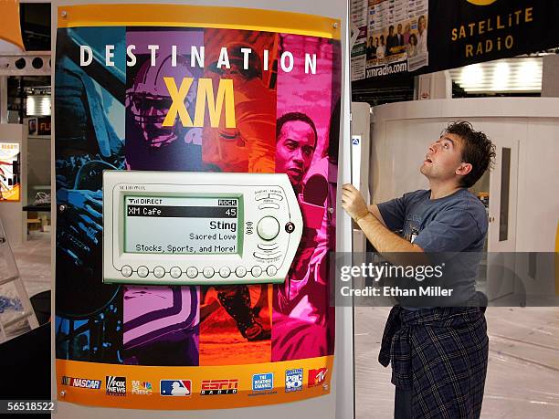 Trade Show Electrical specialist Morgan Shorey works on lighting next to a sign for XM Radio as preparations continue for the 2006 International...