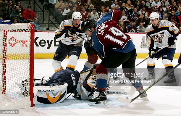 Joe Sakic of the Colorado Avalanche pressures the goal as goaltender Tomas Vokoun of the Nashville Predators gathers the puck for a save during NHL...