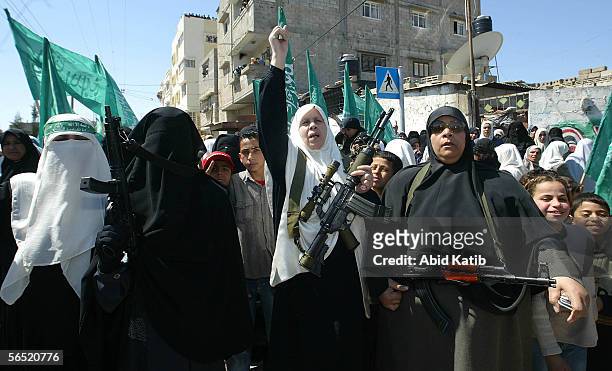 Palestinian woman Mariam Farahat holds a gun as she shouts anti Israel slogans in front of the house of Hamas Founder Ahmed Yassin during his funeral...