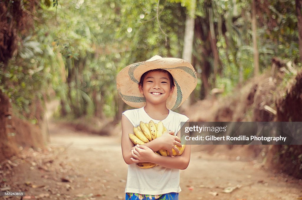 Farm boy holding bananas