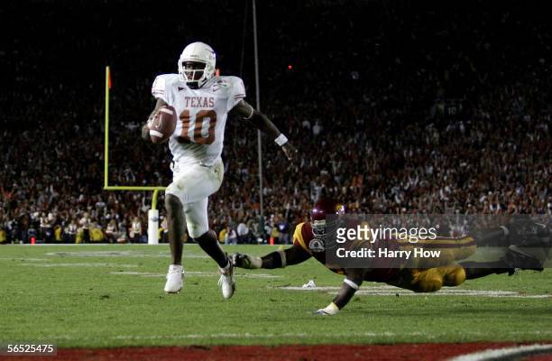 Vince Young of the Texas Longhorns runs past Frostee Rucker of the USC Trojans to score a touchdown and put the Longhorns up by one in the final...