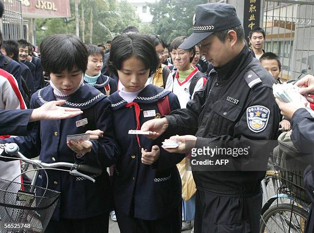 Hand reaches out to receive road-safety instruction cards handed out to some 50,000 middle school students by police, 05 January 2006 in Fuzhou, in...