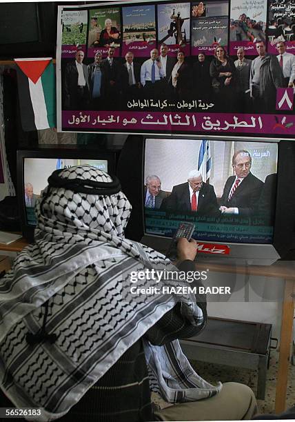 Palestinian shopkeeper watches the news about Israeli Prime Minister Ariel Sharon's grave state of health, 05 January 2006, in the West Bank town of...