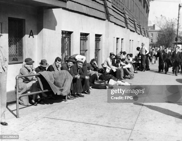 View of baseball fans as they line up outside Wrigley Field the day before tickets go on sale for the World Series between their hometown Chicago...