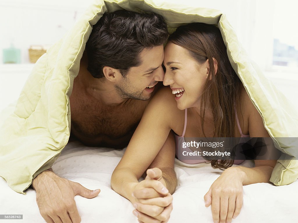 Young couple lying on a bed and smiling