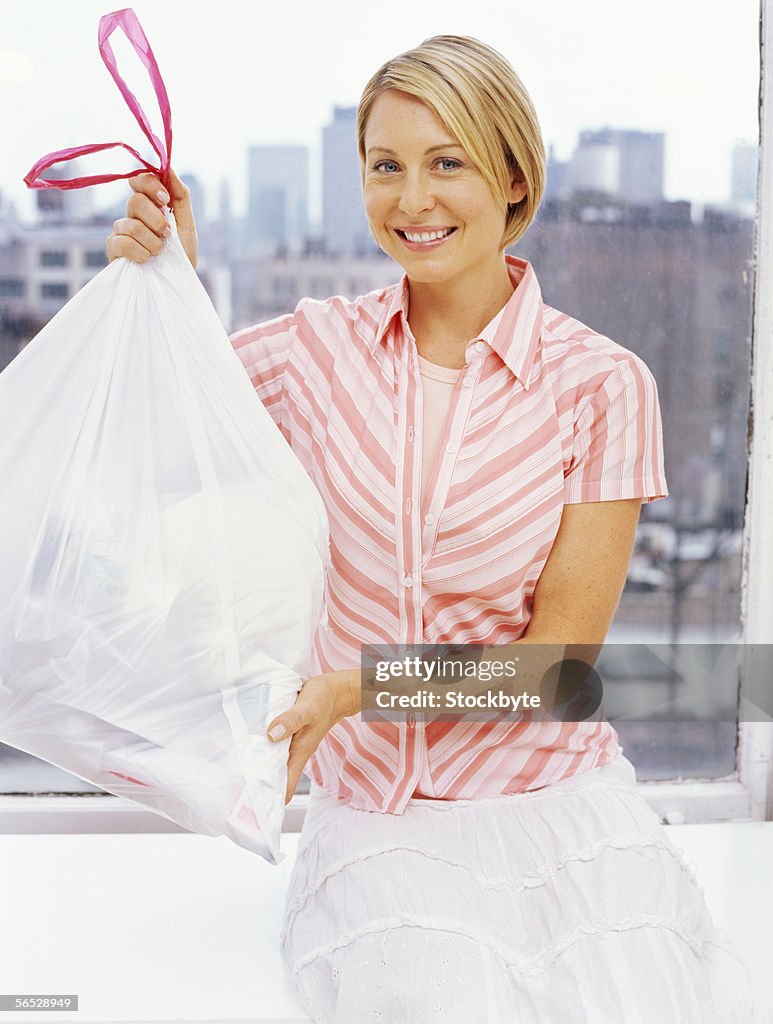 Portrait of a mid adult woman holding a garbage bag