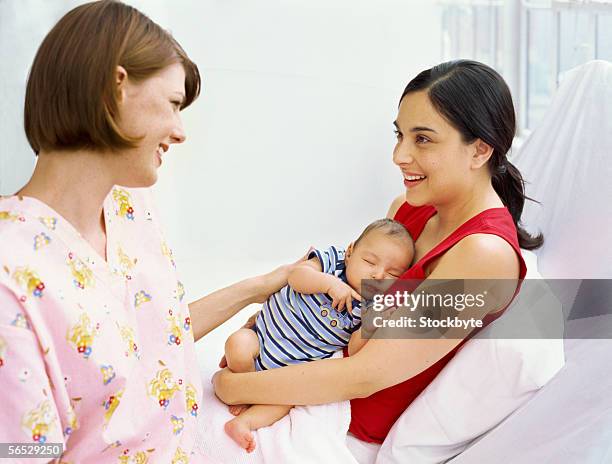 side profile of a mid adult woman talking with another woman holding her son - black hair stock pictures, royalty-free photos & images