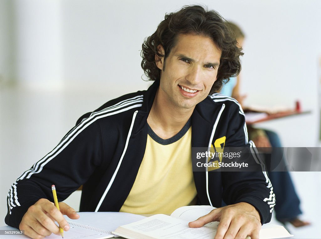 Portrait of a young man sitting in a classroom