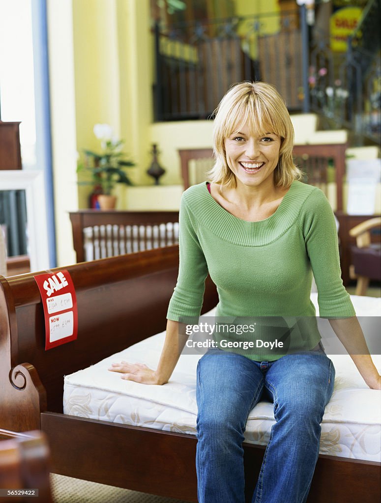 Portrait of a young woman sitting on a bed