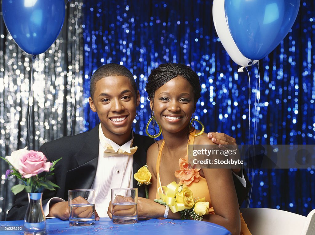 Portrait of a teenage couple sitting at a table and smiling