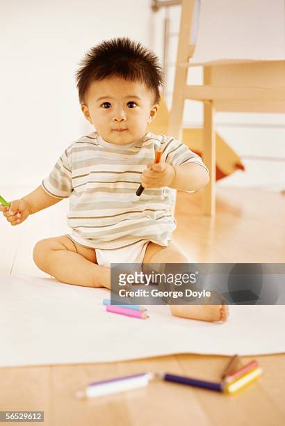 portrait of a baby boy playing with crayons - soltanto un neonato maschio foto e immagini stock