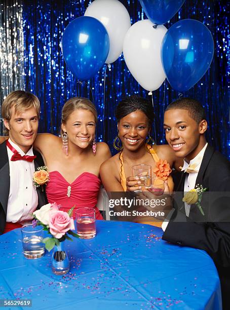 portrait of two teenage couples sitting at a table and smiling - proms stock pictures, royalty-free photos & images