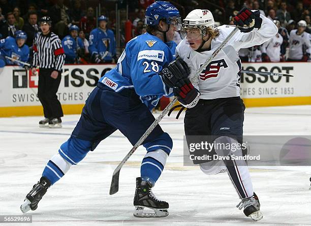 Tj Oshie of Team USA and Teemu Laakso of Team Finland battle for position during their World Jr. Hockey Championship bronze medal game at General...