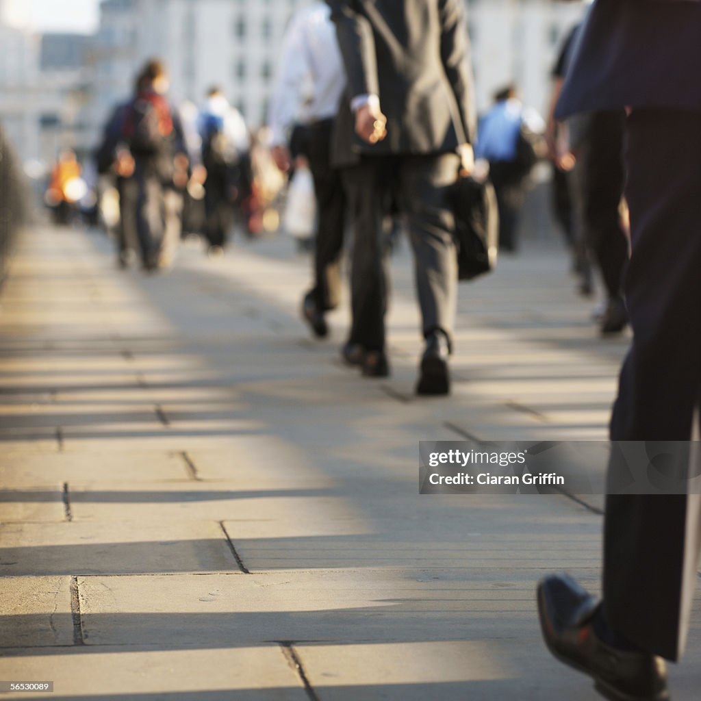 Rear view of a group of people walking on the sidewalk